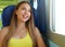 Attractive young woman looking through the train or bus window. Happy train passenger traveling sitting in a seat and looking