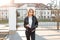 Attractive young woman model in a spring stylish jacket in trendy jeans in white shirt poses near the vintage gate