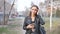 Attractive young woman in the park uses the phone. walk through the city center in the evening. A young woman walks in a