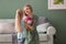 Attractive young woman receiving beautiful flowers from her daughter at home