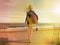 Attractive Young Woman In Short Wet Suit With Surf Board Walking Out To The Sea On A Sunny Beach