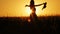 Attractive young woman silhouette dancing outdoors on a sunrise with sun shining bright behind her on a horizon. 4k shot