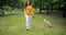 Attractive young woman walking in park with adorable shiba inu dog on grass