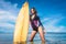 attractive young woman in wetsuit with surfboard posing in ocean at Nusa dua Beach