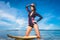 attractive young woman in wetsuit with surfboard posing in ocean at Nusa dua Beach