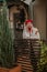 Attractive young woman in white coat and red beret stay near city cafe with baguettes