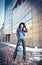 Attractive young woman in a winter fashion shot. Beautiful fashionable young girl in black leather with big hat and blue handbag