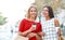 Attractive young women drink take away coffee in summer city