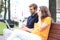 Attrative young couple using laptop computer while sitting on a bench outdoors