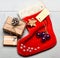 Attributes of christmas. Santa stocking with christmas gift box. Christmas decorative sock light background top view