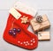 Attributes of christmas. Santa stocking with christmas gift box. Christmas decorative sock light background top view