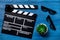 Attributes of film director. Movie clapperboard and sunglasses on blue wooden table background top view