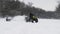 ATV Quad bike drifting on snow. Man on quad bike pulls woman on snowtube on frozen river at winter