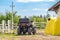 ATV quad bike vehicle standing near wooden fence at farm or horse stable. Back view of all wheel drive motorcycle at farm. Rural