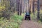 ATV quad with driver and passenger on magic picturesque path in the autumn forest