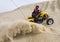 ATV rider spraying sand