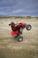 ATV rider wheelie on beach