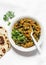 Aubergine spinach vegetarian curry with naan flatbread on a light background, top view. Indian cuisine