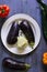 Aubergines with cheese and chili peppers in a pattern on a blue and artistic background