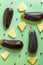 Aubergines with cheese and chili peppers in a pattern on a green and artistic background