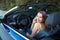 Ð¡aucasian woman talking on phone in a cabriolet car