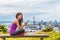 Auckland city runner girl using mobile phone app at skyline summer park. View of cityscape from Mount Eden, in North Island, New