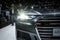 Audi A6 headlight and visitors at the Paris Motor Show. France - October 3, 2018