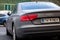 Audi A8 luxury car with a modern grey matte paint with a custom number plate showing that the owner earned money by mining