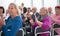 Audience of adult people listen to the speech of the lecturer applauding and smiling