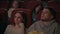 Audience watching film in movie theater. Couple watching bored movie
