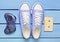 Audio cassette, gamepad, sneakers shoes on a turquoise pastel background. Old-fashioned technologies. Top view. Flat lay