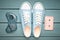 Audio cassette, gamepad, sneakers shoes on a turquoise pastel background. Old-fashioned technologies. Top view. Flat lay.