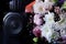 Audio speaker and headphones on a black background next to a modern designer bouquet. Bouquet concept for an award ceremony in the