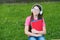 Audio to rock your life. Small child listen to music on green grass. Little girl wear audio headphones. Listening to