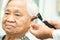 Audiologist or ENT doctor use otoscope checking ear of asian senior woman patient treating hearing loss problem