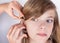 Audiologist fitting a hearing aid to an adorable young girl patient