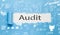 Audit text written paper on blue background