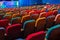 The auditorium in the theater. Multicolored spectator chairs. One person in the audience