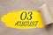 august 03. 03th day of the month, calendar date.Hole in paper with edges torn off. Yellow background is visible through