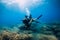 August 20, 2020. Anapa, Russia. Couple of scuba divers glides underwater in transparent blue sea. Scuba diving in clear ocean