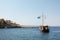 August 23rd 2019 - Sithonia, Greece - Rocky coast and tourist boat in Kelyfos islet, Neos Marmaras