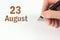 August 23rd. Day 23 of month, Calendar date. The hand holds a black pen and writes the calendar date. Summer month, day of the