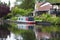 August 3 2019 - Harefield, England: Canal with house and boat reflected in water