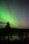 Aurora borealis above forest pond in northern taiga