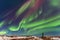 Aurora borealis above the silhouette maa in Iceland. Green northern lights. Starry sky with polar lights.