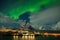 Aurora borealis dancing on mountain in fishing village at Reine and Sakrisoy, Lofoten, Norway Visiting the Lofoten Islands.