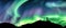 Aurora borealis glowing over silhouette hiker standing on the mountain in the night sky