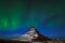 Aurora Borealis from Iceland. Beautiful green Northern Lights on the dark blue night sky with peak with snow, Kirkjufell