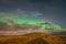 Aurora Borealis in Iceland northern lights bright beams over clouds during full moon