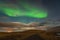 Aurora Borealis in Iceland northern lights bright beams rising in green beams over icelandic landscape